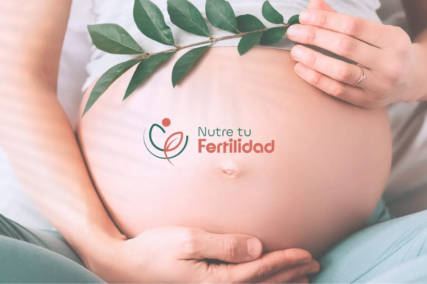Mujer embarazada con el logotipo de Nutre tu Fertilidad sobre el vientre