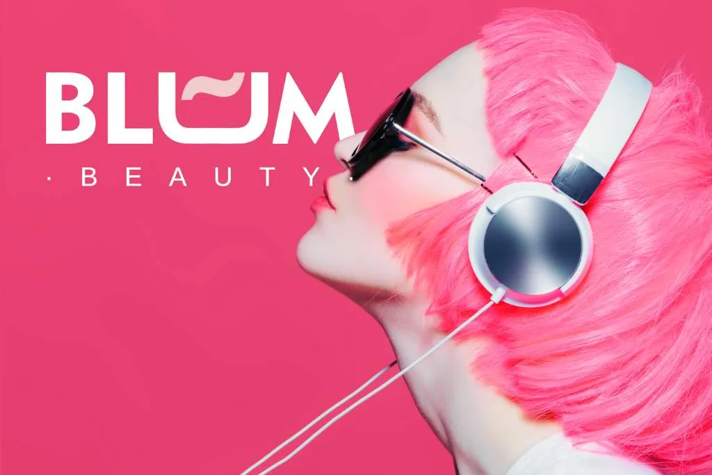 Mujer con el pelo rosa y auriculares junto al logotipo de Blum Beauty