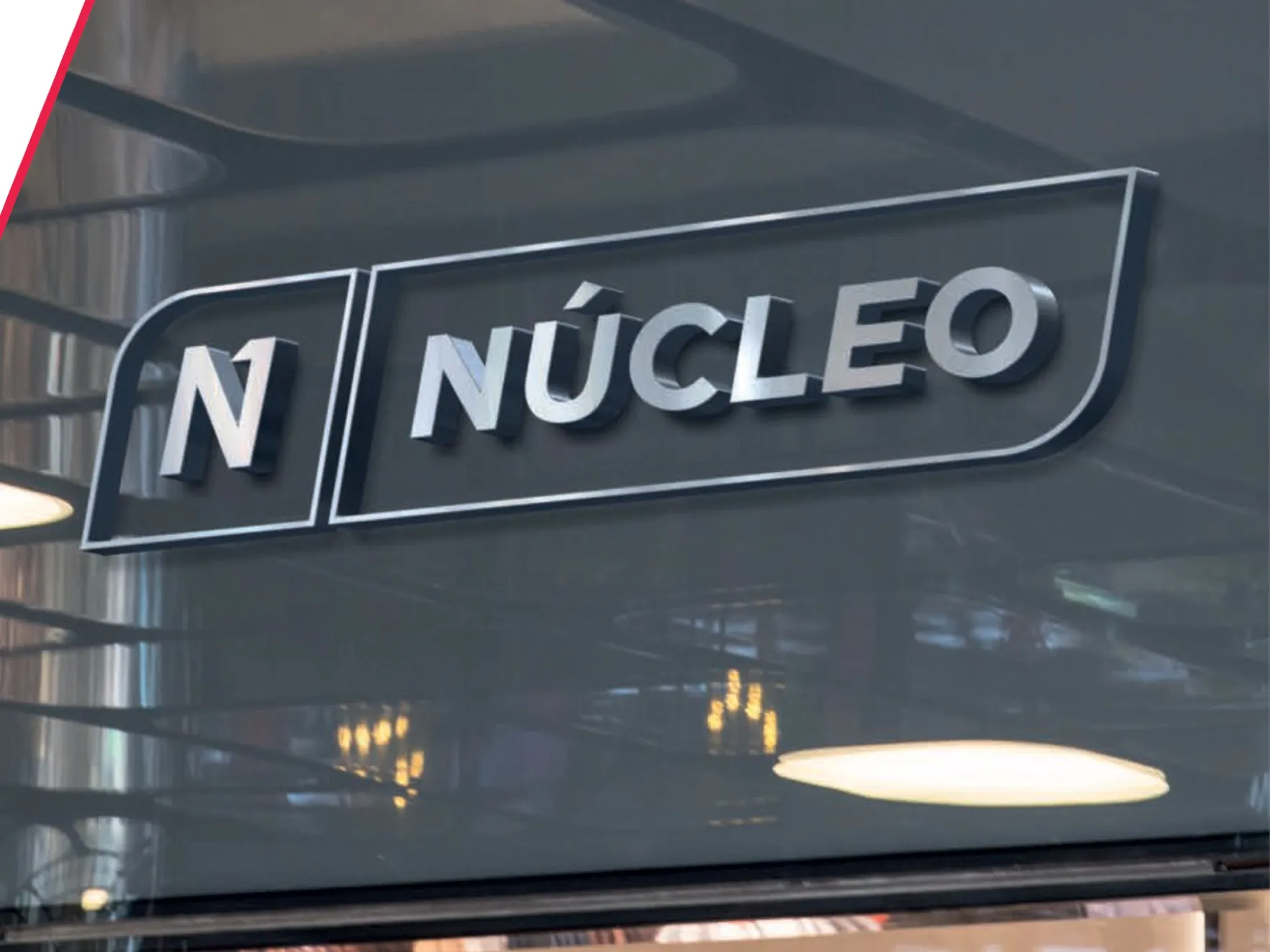 Letrero corpóreo de Núcleo en la fachada de cristal de unas oficinas