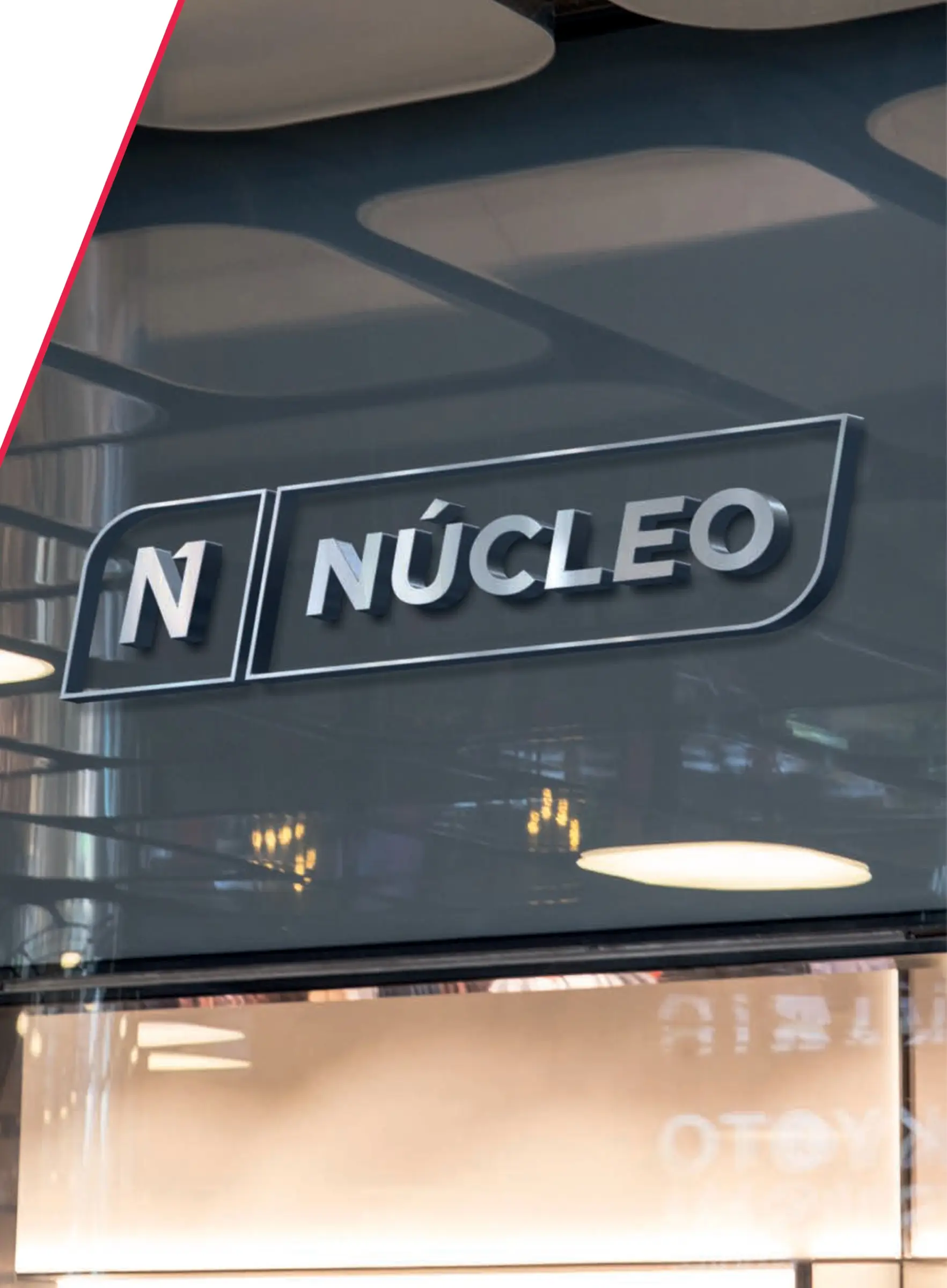 Letrero corpóreo de Núcleo en la fachada de cristal de unas oficinas