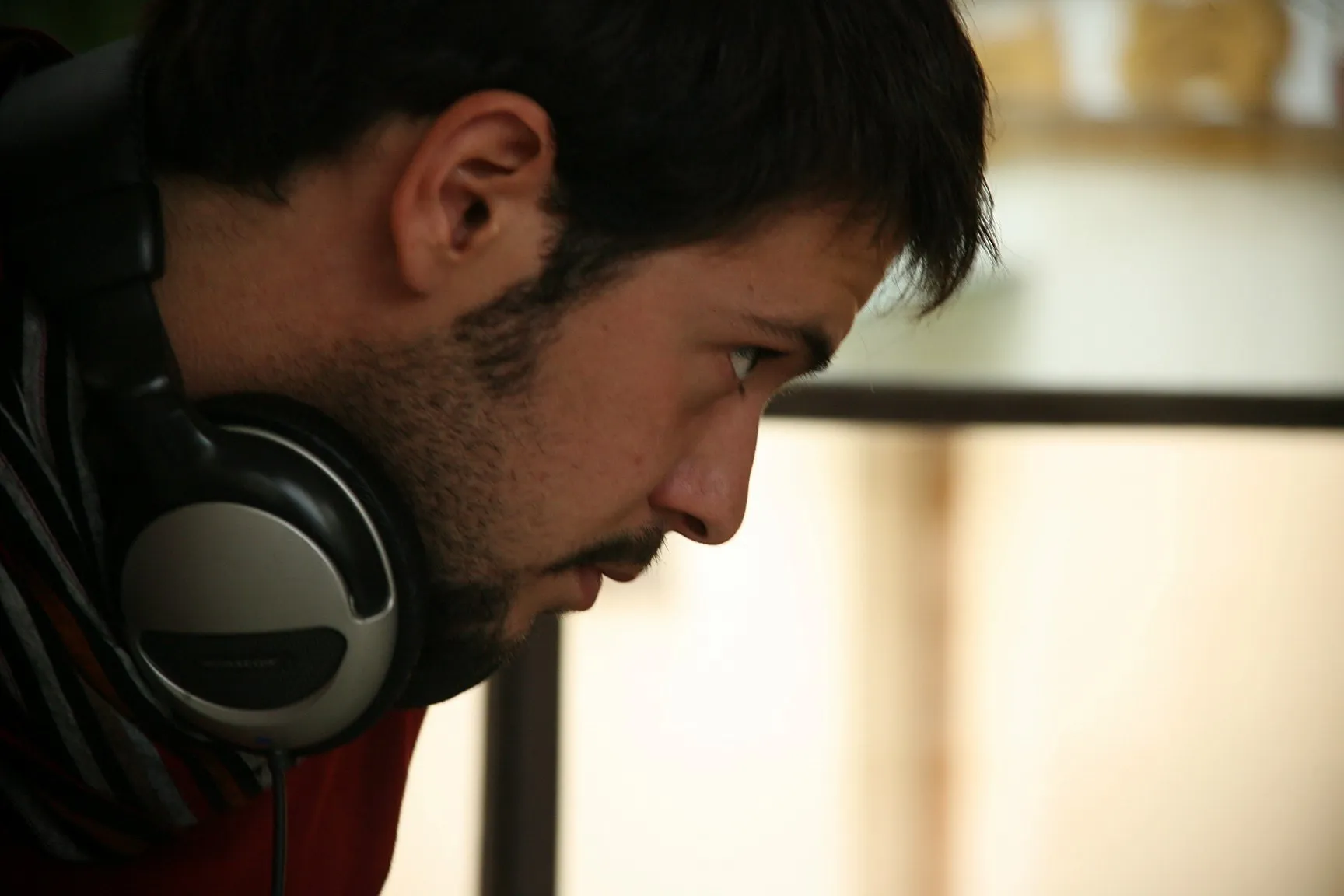 Perfil de un técnico de sonido con los cascos al cuello, atento a la escena