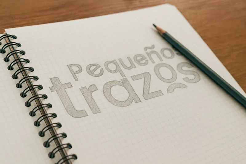 Boceto a lápiz del logotipo de Pequeños Trazos en una libreta