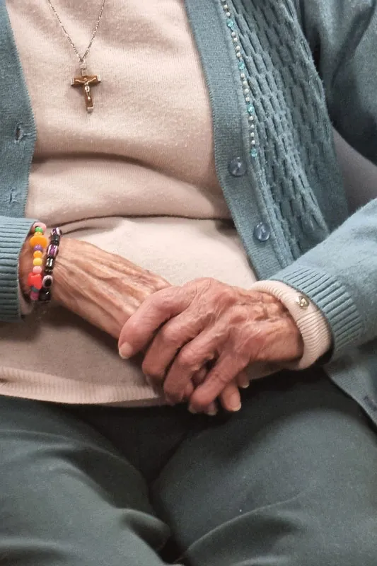Retrato de las manos de una residente sentada